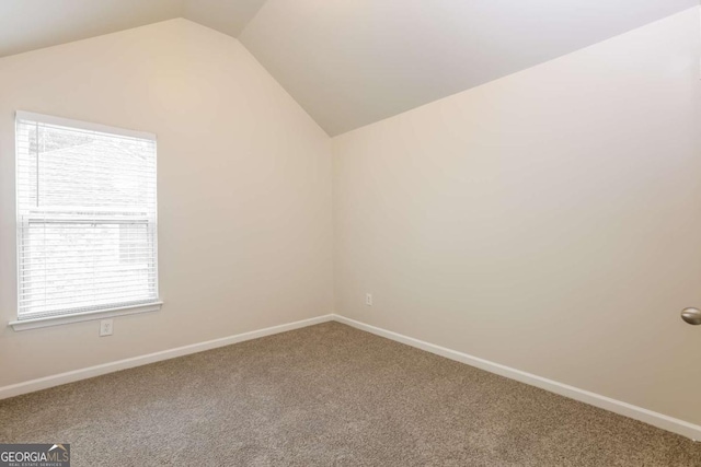 carpeted empty room with plenty of natural light and lofted ceiling