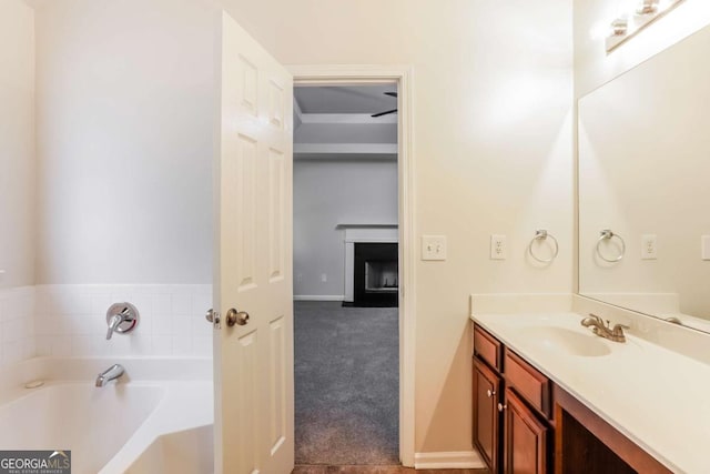 bathroom with vanity, ceiling fan, and a bath