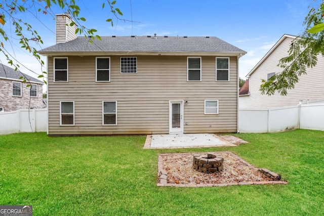 rear view of house featuring a patio area, a yard, and an outdoor fire pit