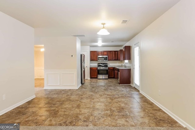 kitchen featuring appliances with stainless steel finishes, decorative light fixtures, and sink