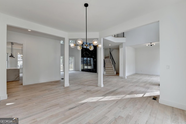 unfurnished dining area with a notable chandelier and light hardwood / wood-style floors