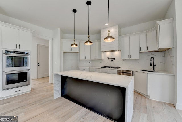 kitchen with white cabinetry, sink, pendant lighting, and appliances with stainless steel finishes