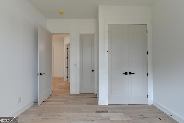 unfurnished bedroom featuring a closet and light hardwood / wood-style flooring