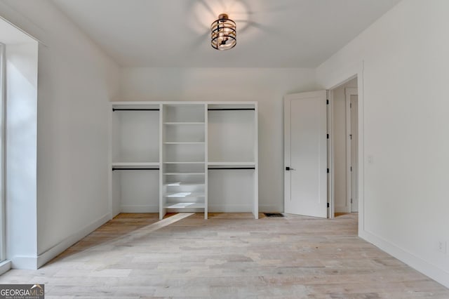 unfurnished bedroom with a closet and light hardwood / wood-style flooring