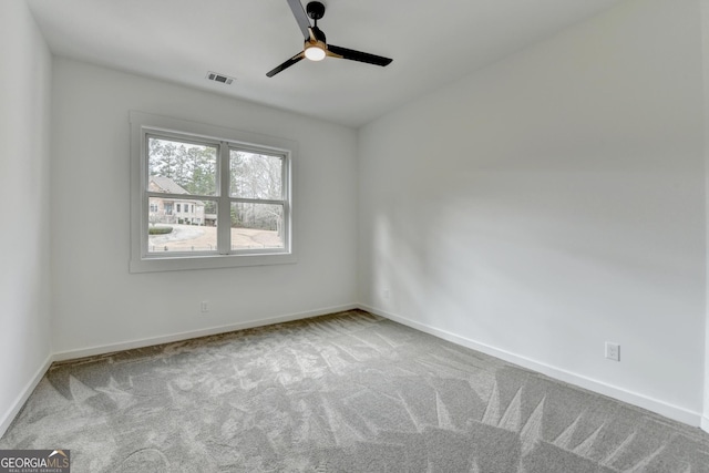 spare room with ceiling fan and light colored carpet