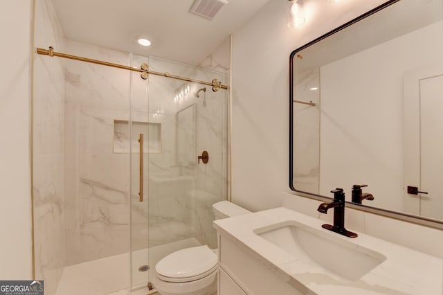 bathroom with vanity, toilet, and a shower with shower door