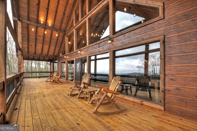 unfurnished sunroom with lofted ceiling with beams, a wealth of natural light, and wood ceiling