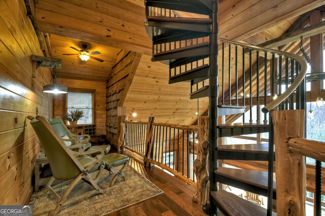 stairs with hardwood / wood-style flooring, lofted ceiling with beams, wood walls, and wood ceiling