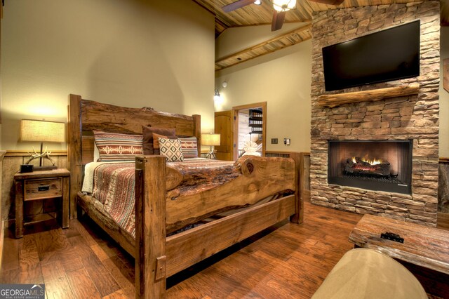 bedroom with ceiling fan, wooden ceiling, high vaulted ceiling, hardwood / wood-style floors, and a fireplace