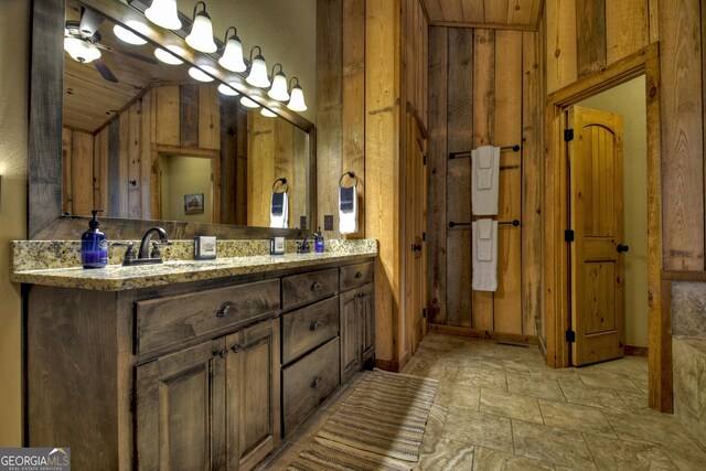 bathroom featuring vanity, wooden walls, and ceiling fan