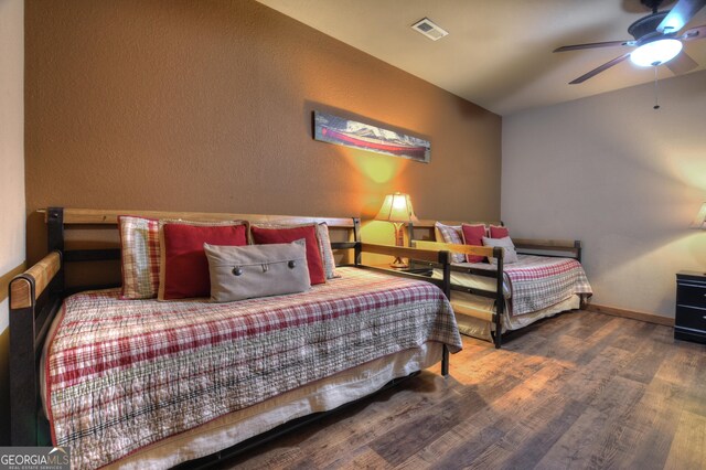 bedroom featuring ceiling fan and dark wood-type flooring