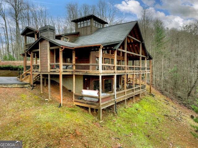 rear view of property with a wooden deck