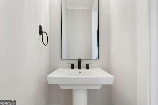 bathroom with ornamental molding and sink