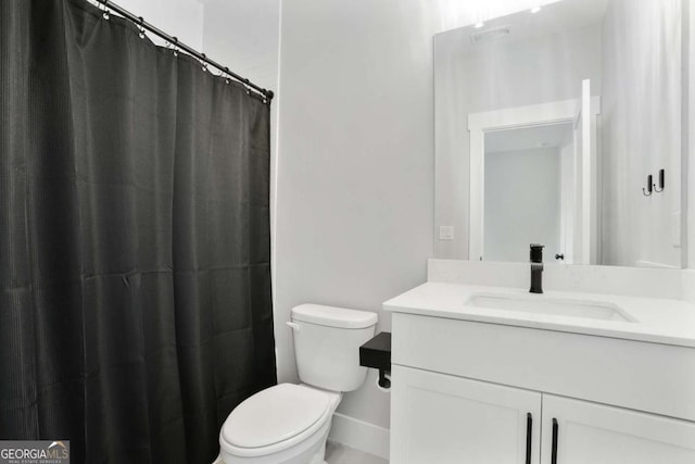 bathroom featuring vanity, toilet, and walk in shower