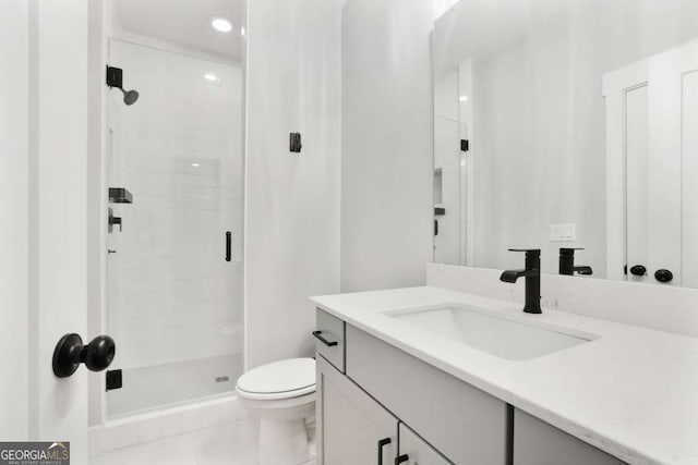 bathroom featuring tile patterned flooring, vanity, toilet, and a shower with door