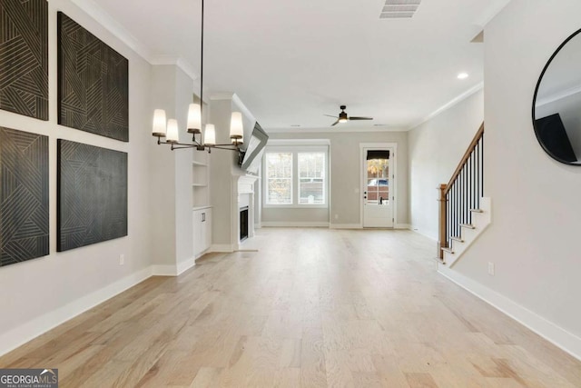 unfurnished living room featuring ceiling fan with notable chandelier, light hardwood / wood-style flooring, and crown molding