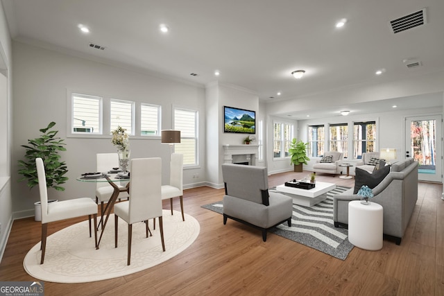 living room with crown molding and light hardwood / wood-style floors