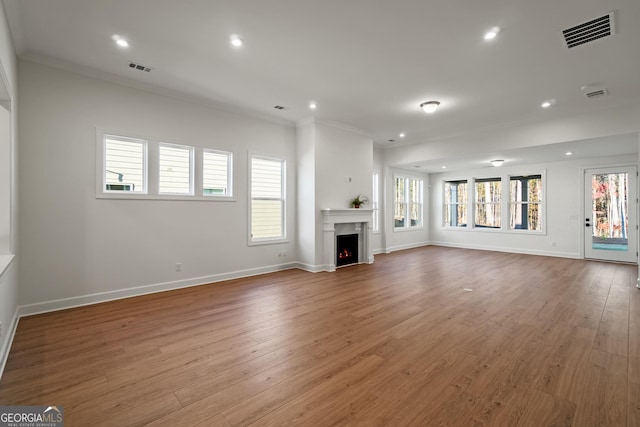 unfurnished living room with crown molding and hardwood / wood-style flooring