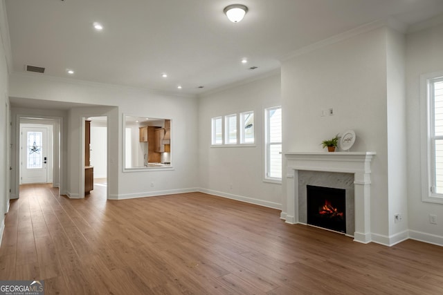 unfurnished living room featuring a fireplace, plenty of natural light, and ornamental molding