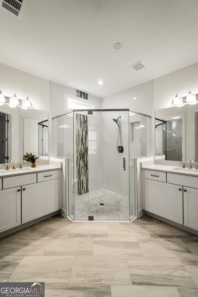 bathroom featuring a shower with shower door and vanity