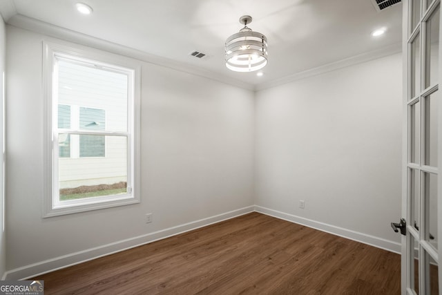 empty room with dark wood-type flooring and crown molding