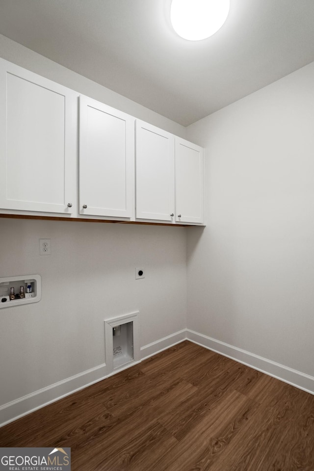 laundry room featuring dark wood-type flooring, hookup for a washing machine, electric dryer hookup, and cabinets