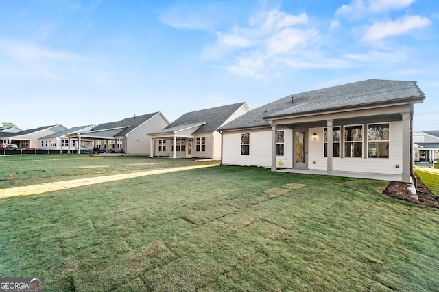 rear view of property with a lawn