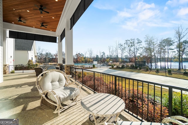 exterior space featuring ceiling fan, a patio area, and a water view