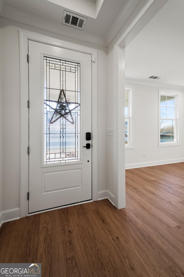 entrance foyer with plenty of natural light, crown molding, and hardwood / wood-style floors