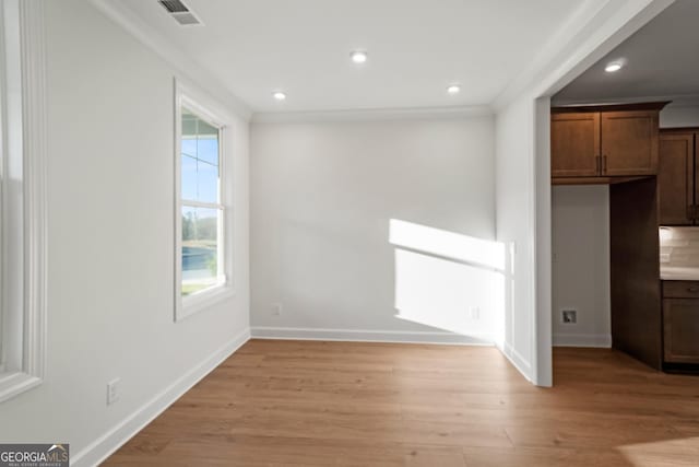 unfurnished dining area with ornamental molding and light hardwood / wood-style flooring