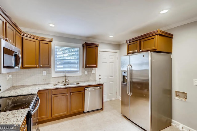 kitchen featuring backsplash, light stone counters, sink, and appliances with stainless steel finishes