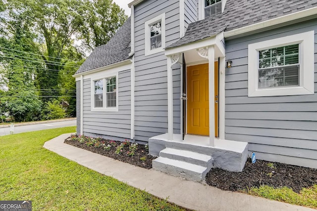 view of exterior entry with a lawn