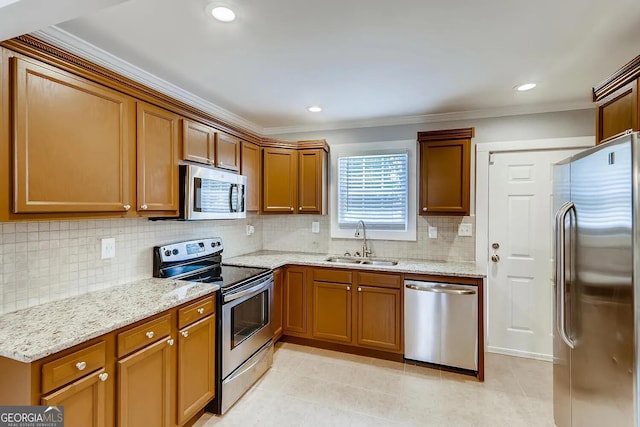 kitchen with light stone counters, sink, stainless steel appliances, and crown molding