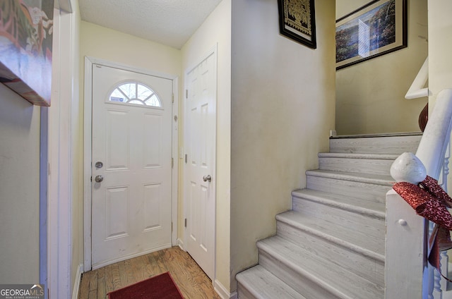 foyer with light hardwood / wood-style floors and a textured ceiling