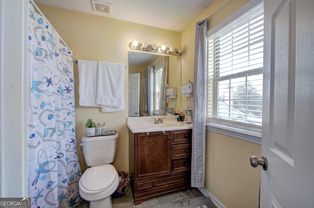 bathroom featuring vanity, a textured ceiling, and toilet