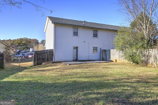 back of house with a lawn and a patio area