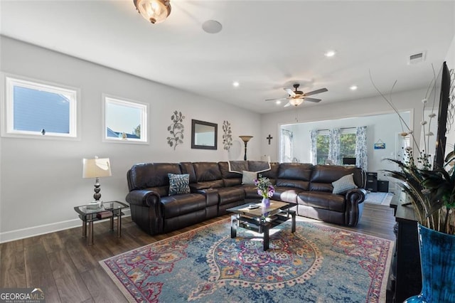 living room with ceiling fan and dark wood-type flooring