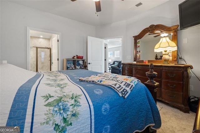 bedroom featuring ceiling fan, light colored carpet, and ensuite bath