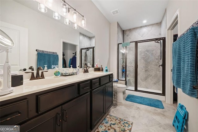 bathroom featuring tile patterned flooring, vanity, a shower with shower door, and toilet