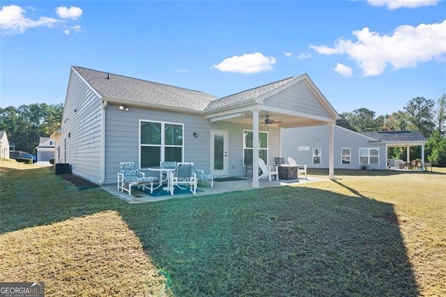 rear view of property featuring ceiling fan, a yard, and a patio