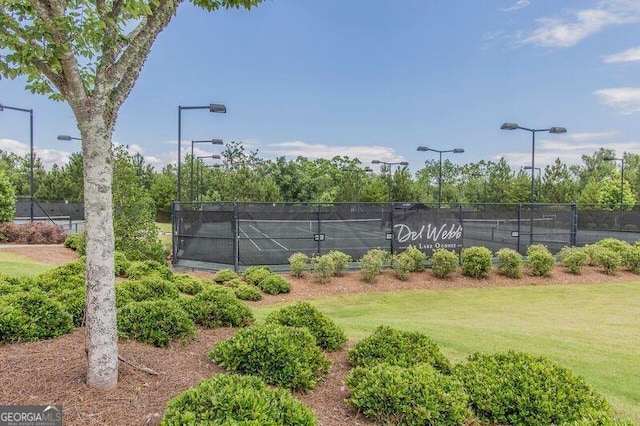 view of tennis court with a yard