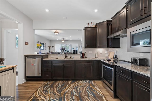 kitchen featuring tasteful backsplash, stainless steel appliances, ceiling fan, dark wood-type flooring, and sink