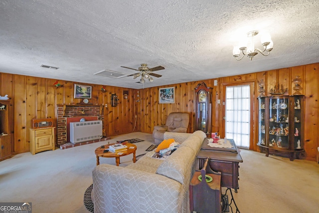 carpeted living room with heating unit, wooden walls, and a textured ceiling