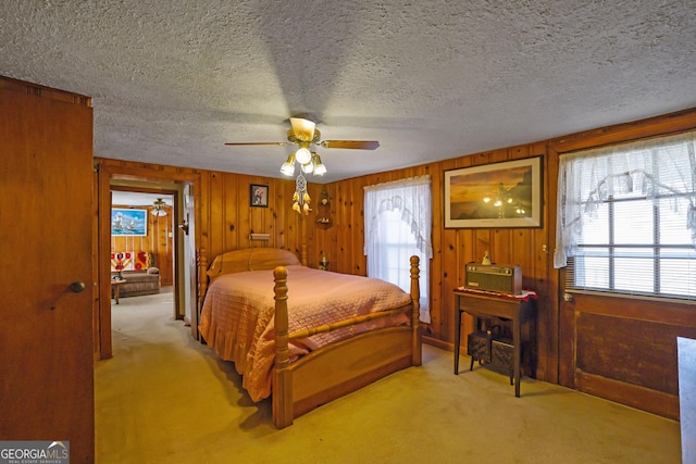 bedroom featuring a textured ceiling, light colored carpet, and multiple windows