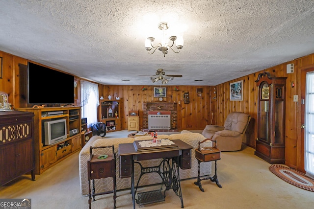 carpeted living room with wood walls, a healthy amount of sunlight, and a textured ceiling