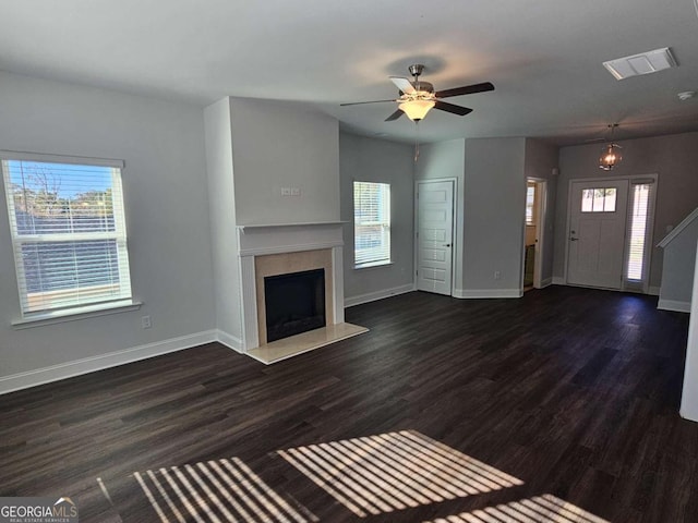 unfurnished living room with baseboards, visible vents, dark wood finished floors, and a fireplace