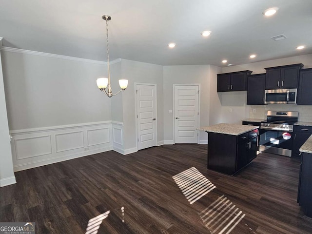 kitchen with appliances with stainless steel finishes, light stone counters, dark wood-style flooring, a center island, and recessed lighting