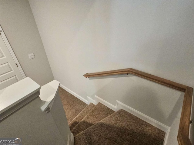 stairway featuring carpet and baseboards