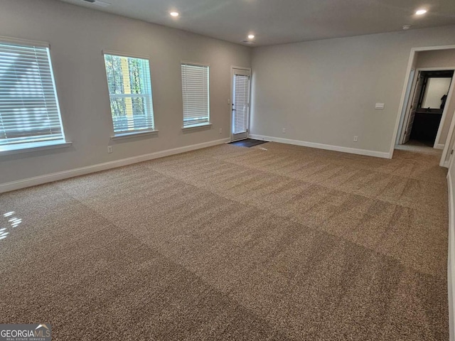 carpeted empty room with baseboards and recessed lighting