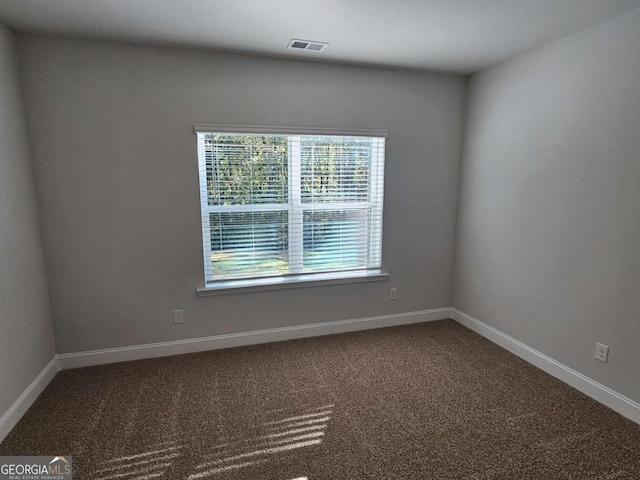 spare room featuring baseboards, visible vents, and carpet flooring